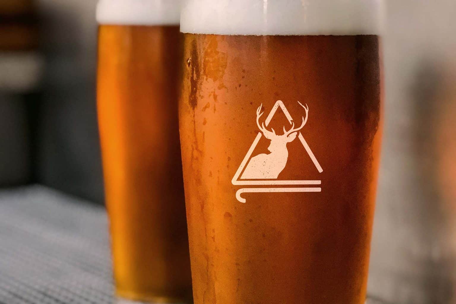 A photo of a beer glass with the Deer Lodge logo.